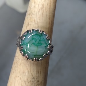 This Ladies ring is a Dragon Vein Agate 16 mm size 10. It set in a Gallery bezel and has been oxidized. Very Nice blossom band.