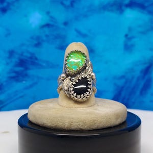 ladies ring with 2- 10 x 14mm stones, 1 opal triplet and 1 black onyx. Gallery bezel,leaves,and a blossom. size 8 1/4 new style wide band