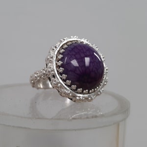 This is a ladies Ring is a size 6 1/2 and has a 16 mm Dragon Vein Agate set in a blossom bezel, and a very nice detailed blossom band.