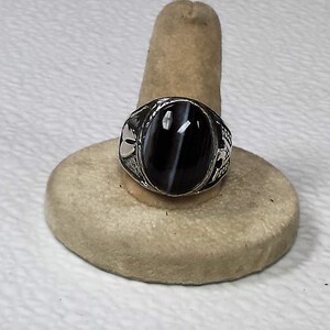 This ring is a banded agate black,white, size 10 3/4 It has a thunder bird on one side and a hoof print on the other side.