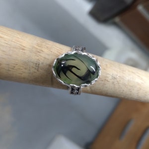 Ring is a size 9 3/4 and has a 18 x 13 mm Dragon Vein agate set in a HONEY COMB bezel, and a BLOSSOM  band. unique stone.