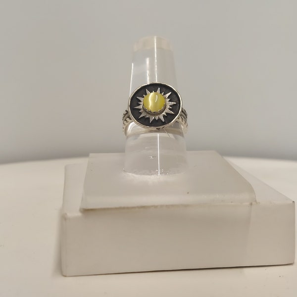 Ring has 6 mm yellow cats eye set in the middle of the sun. It is made of sterling silver size 6 1/2 with a detailed band