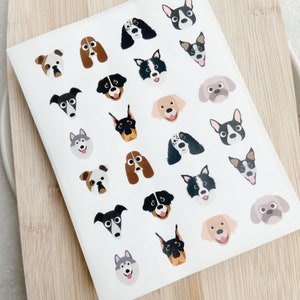 May include: A sheet of colourful dog stickers featuring various breeds, including a black and white border collie, a brown and white dachshund, a black and white husky, and a brown and white cocker spaniel.