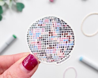 Op de afbeelding: Een ronde sticker met een kleurrijk discobalontwerp. De sticker heeft een witte rand en is bedekt met kleine vierkantjes in verschillende kleuren, waaronder roze, blauw en grijs. De tekst "@d.prince.designs" staat op de sticker.