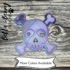 May include: A purple iridescent skull and crossbones design. The skull has a detailed design with a textured surface.  More Colors Available.