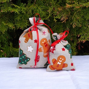 Piccolo, grande sacco di Natale. Sacchetti regalo di Natale in tessuto di lino con omino di pan di zenzero. Sacchetti regalo di Babbo Natale con fascia rossa. Sacchetti per biscotti di Natale