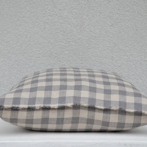 May include: A gray and white gingham pillow with a frayed edge.