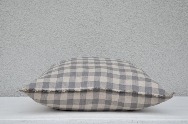 May include: A gray and white gingham pillow with a frayed edge.