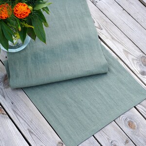 Close-up of sage green stone washed linen table runner showing the natural linen texture