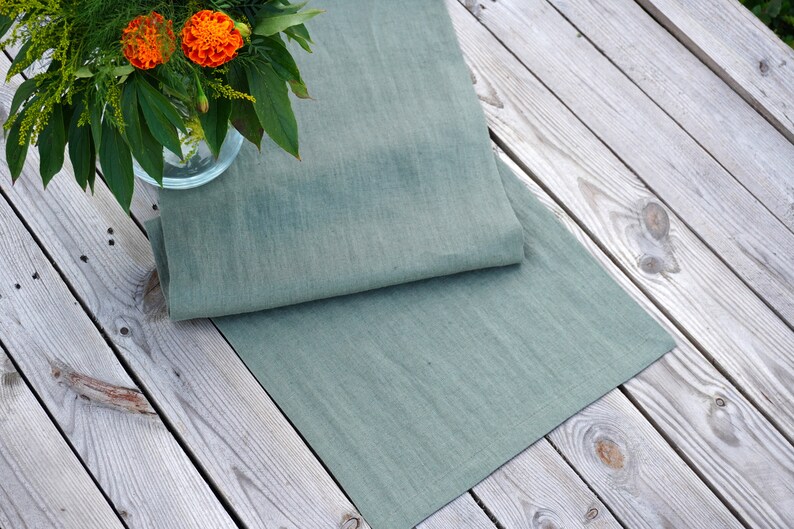 Close-up of sage green stone washed linen table runner showing the natural linen texture