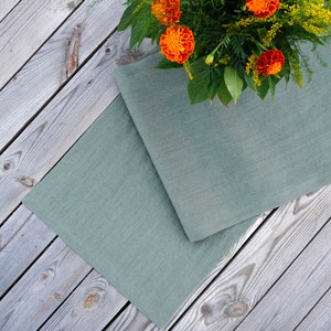 Premium European stone washed linen table runner draped a rustic wooden dining table