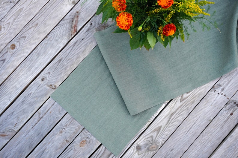 Premium European stone washed linen table runner draped a rustic wooden dining table