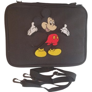 May include: Black rectangular bag with a zipper closure and a detachable shoulder strap. The bag features an embroidered image of Mickey Mouse in his classic outfit: red shorts, yellow shoes, and white gloves.