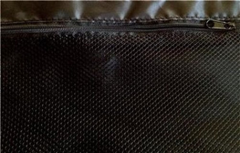 May include: Close-up of a black mesh fabric with a zipper at the top. The zipper is dark gray and has a small metal pull. The mesh has a diamond pattern and is likely part of a bag or other container.