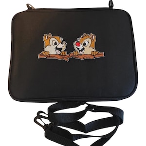 May include: Black rectangular bag with a shoulder strap. The bag features an embroidered image of two cartoon chipmunks peeking over a brown branch. The chipmunks have brown and tan fur, with one having a red nose.