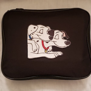 May include: Black zippered case featuring an embroidered patch of two Dalmatian dogs. The dogs are white with black spots, and one wears a red collar. The case has a black zipper and trim.