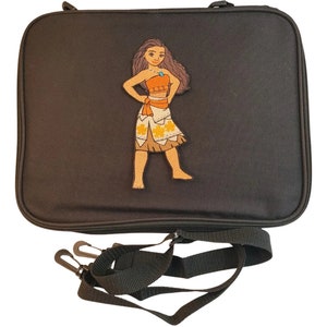 Puede incluir: Funda negra para port&aacute;til con cierre de cremallera y correa para el hombro desmontable. La funda presenta un gr&aacute;fico colorido de un personaje de dibujos animados con una parte superior naranja y una falda estampada. Dise&ntilde;ada para proteger un port&aacute;til o tableta.