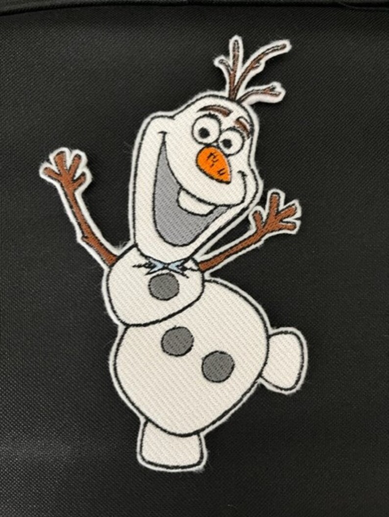 May include: Embroidered patch featuring Olaf, the cheerful snowman from Frozen. The patch has a white body with black accents, a carrot nose, and twig arms. The background is black.