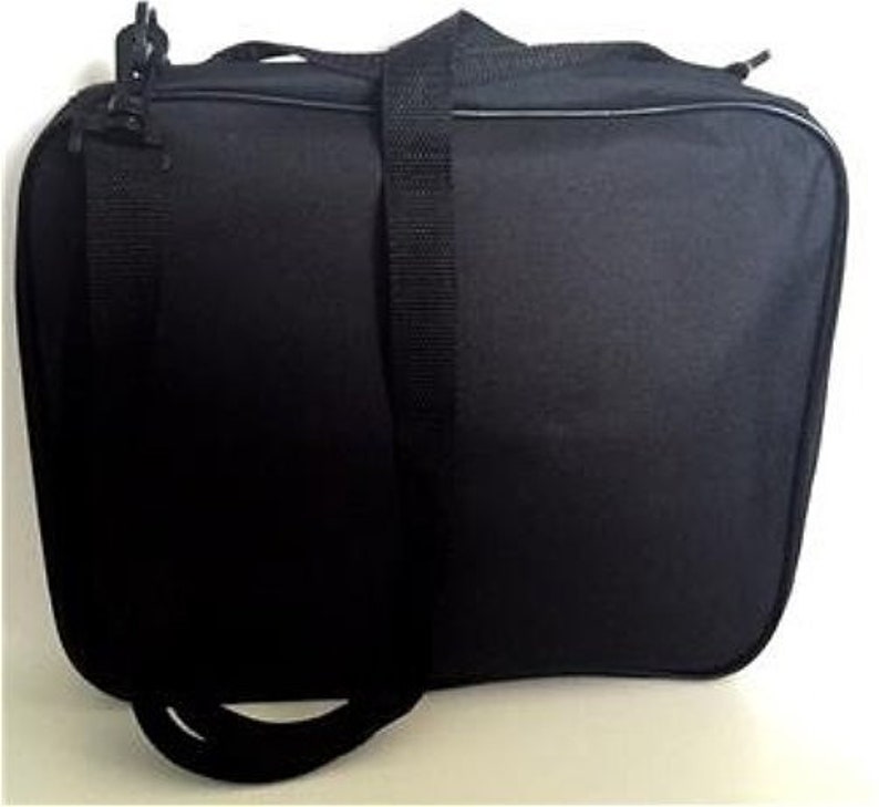 Puede incluir: Bolsa de lona rectangular negra con una correa para el hombro y un asa superior. La bolsa tiene un cierre de cremallera y una correa negra ajustable. La bolsa est&aacute; hecha de un material duradero y es adecuada para viajar o transportar art&iacute;culos.