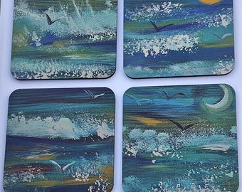 May include: Set of four square coasters featuring abstract seascapes with blue, green, and white paint. Each coaster depicts a different scene with waves, seagulls, and a sun or moon.