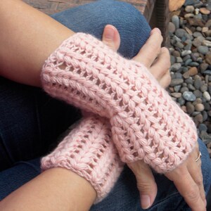 Pink hand/arm warmers covering the hands and wrists.