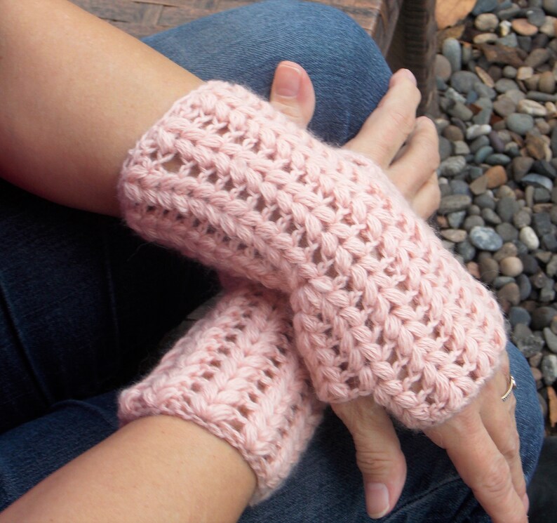 Pink hand/arm warmers covering the hands and wrists.