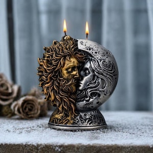 May include: A decorative candle holder depicting the sun and moon. The sun is gold, and the moon is silver. Two lit candles are on top. The base has detailed patterns. The background is blurred, with a snowy surface in the foreground.