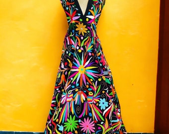May include: A black maxi dress with a V-neckline and colorful embroidery featuring flowers, birds, and geometric patterns.