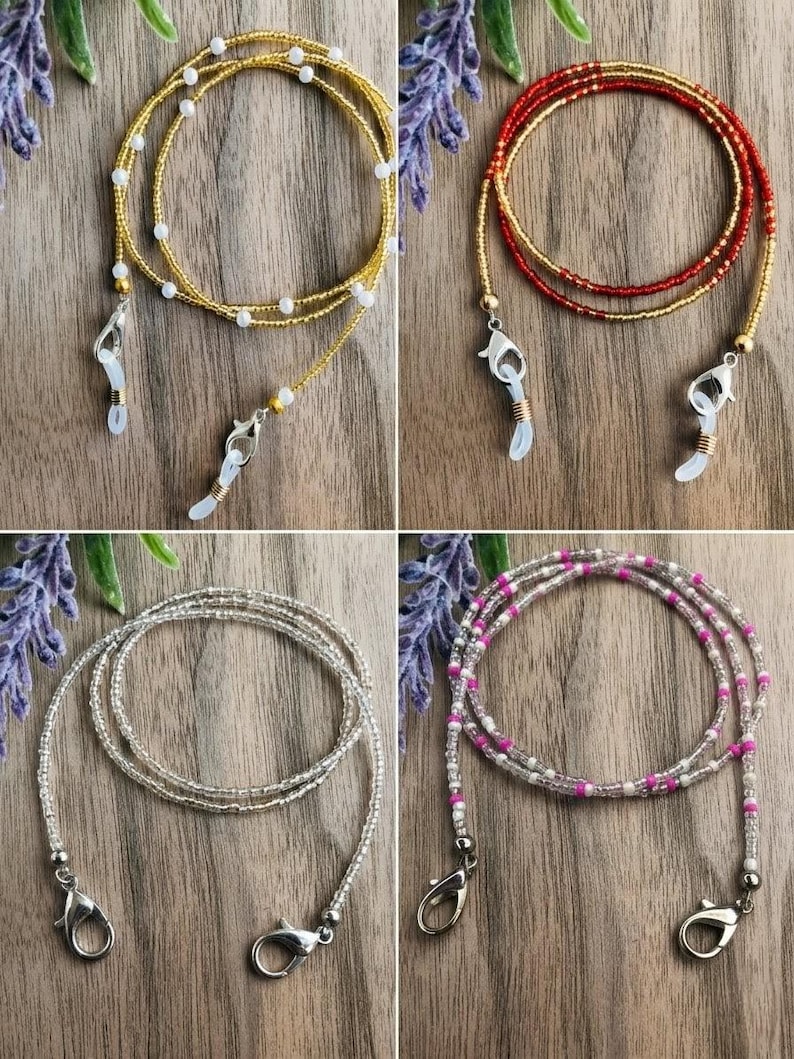 Puede incluir: Cuatro cadenas para gafas hechas de cuentas con varias combinaciones de colores. Una es dorada con cuentas blancas, una es roja y dorada, una es plateada transparente y una es rosa, blanca y transparente. Cada cadena incluye cierres de mosquet&oacute;n.