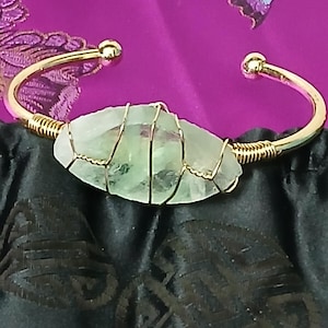Pulseira vintage ajustável artesanal com pedra verde-clara, vidro e detalhes em dourado.