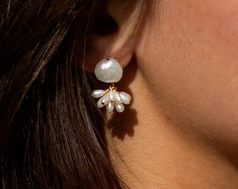 May include: A pair of gold earrings with a large white pearl and smaller white pearls dangling below.