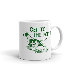 May include: White ceramic mug with a green illustration of a pointing dog and the text "GET TO THE POINT!"