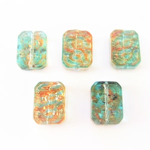 May include: Five rectangular glass beads with a teal and orange marbled pattern. The beads are translucent and have a slightly iridescent finish.