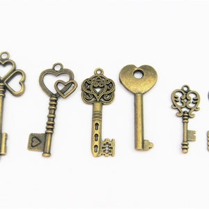 May include: Six antique-style skeleton keys with different designs, including a clover, heart, and ornate patterns. The keys are made of a gold-toned metal and have a vintage look.