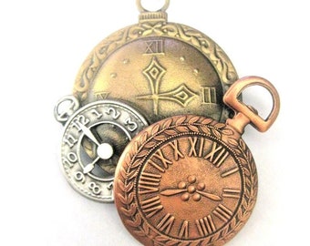 May include: Three antique-style pocket watches with Roman numeral faces. The top watch has a gold-toned face with a diamond-shaped design in the center. The middle watch has a silver-toned face with black hands. The bottom watch has a copper-toned face with a floral design in the center.