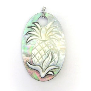 May include: A silver oval-shaped pendant with a carved pineapple design. The pendant is made of iridescent mother-of-pearl.