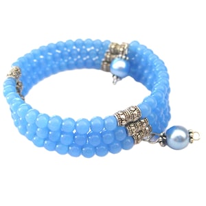May include: A light blue beaded bracelet with silver accents and a pearl charm.