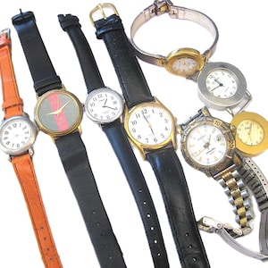 May include: A collection of wristwatches with various band styles and face designs. The watches feature leather, metal, and orange bands. The watch faces display numbers and hands, with gold and silver tones.