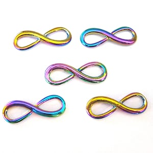 May include: Five iridescent infinity symbol charms in various rainbow colors. The charms are made of metal and have a smooth, polished finish.