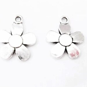 May include: Two silver-toned metal flower charms with a loop at the top for attaching to jewelry or crafts.