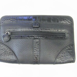 May include: Black leather clutch with a crocodile embossed pattern and a zippered pocket.