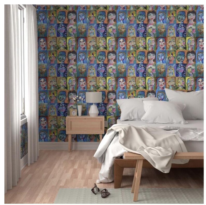 May include: A bedroom with a bed, nightstand, and a lamp. The wall is covered in wallpaper with a pattern of colorful faces.