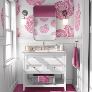 May include: A white bathroom vanity with three drawers and a lower shelf. The vanity has a white countertop with a sink and chrome faucets. The walls are white with a pink and white seashell pattern wallpaper. The floor is pink and white striped.