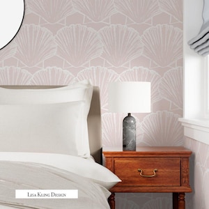 May include: A bedroom scene featuring a bed with white bedding, a wooden nightstand, and a lamp with a white shade. The lamp has a gray marble base. The wall is decorated with a pink seashell pattern. The text "Lisa Kling Design" is visible.