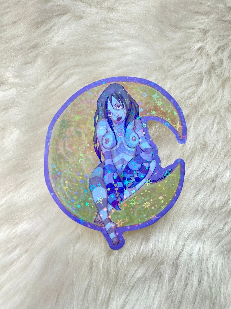 May include: A holographic sticker of a woman sitting on a crescent moon with stars. The woman is wearing a blue and white striped outfit and has long black hair. The sticker is on a white fuzzy background.
