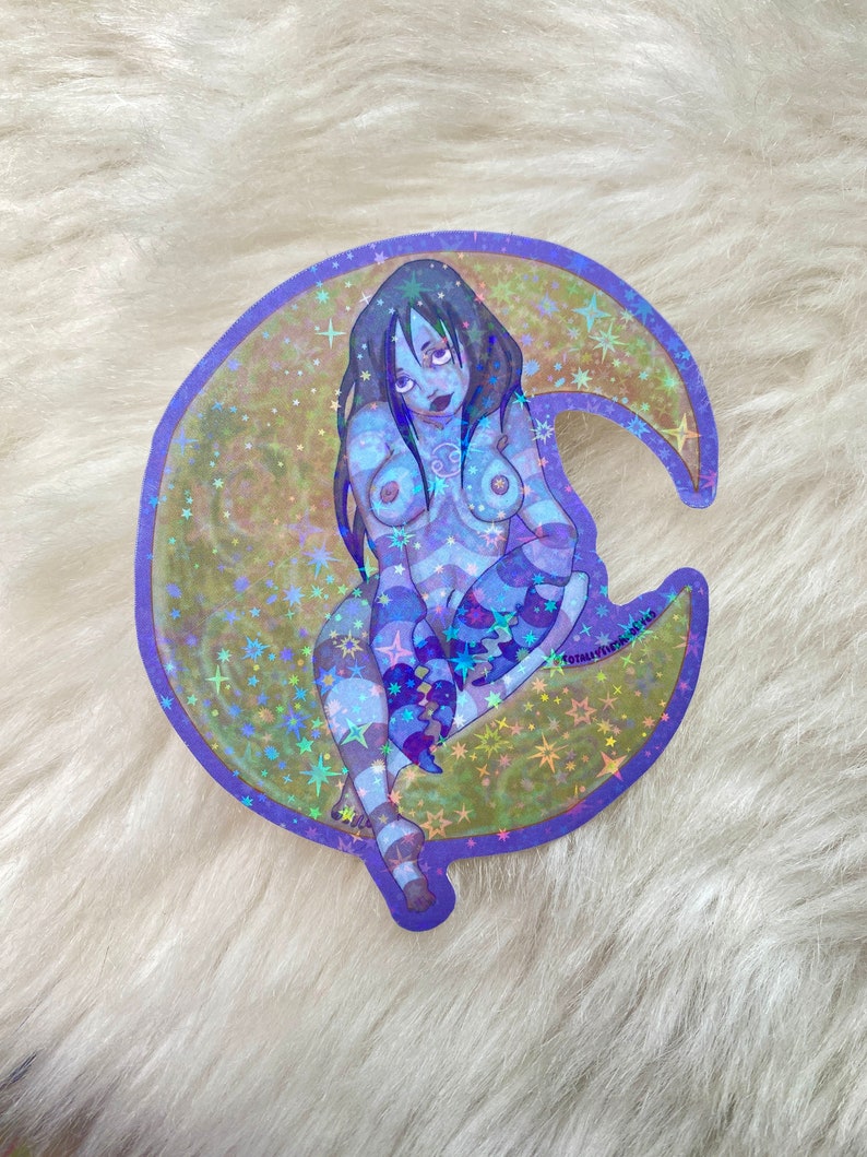 May include: A holographic sticker featuring a woman with long black hair sitting on a crescent moon. The moon is surrounded by stars and has a purple outline. The woman is wearing a blue and white striped outfit and has a tattoo of a crab on her chest.