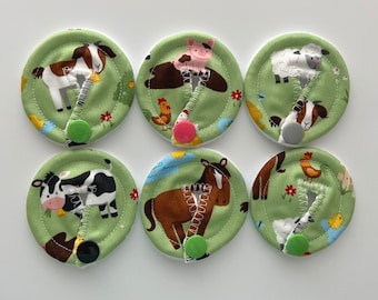 May include: Six green fabric circles with different farm animal designs. Each circle has a green button in the center.