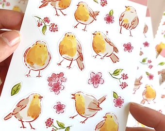 Könnte beinhalten: Eine Bogen mit Aufklebern mit niedlichen, illustrierten Rotkehlchen mit rosa Blüten und grünen Blättern. Die Aufkleber sind auf weißem Hintergrund und haben oben den Text "chalume cute prints, cards, stickers & more".