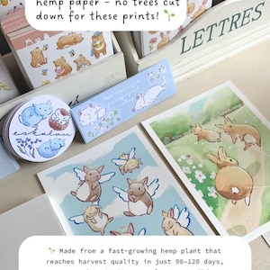 Op de afbeelding: Een display van milieuvriendelijke prints op hennep papier, met illustraties van dieren. De tekst vermeldt dat het papier boomvrij is en gemaakt van hennepvezels en katoenlinters.