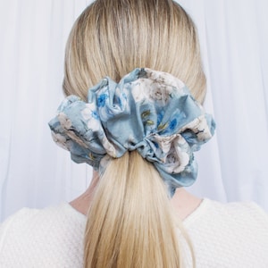 May include: A blue and white floral patterned scrunchie for hair.